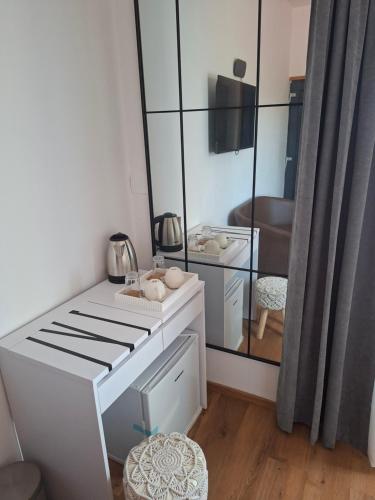 a white kitchen with a mirror in a room at Apartments and Rooms "Almira" in Pula