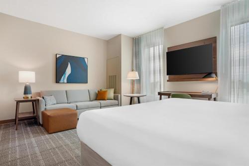 a hotel room with a bed and a couch at Drury Inn & Suites Destin Miramar Beach in Destin