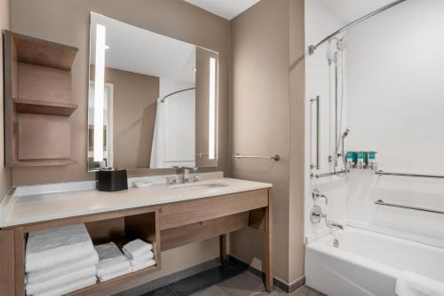 a bathroom with a sink and a tub and a mirror at Drury Inn & Suites Destin Miramar Beach in Destin