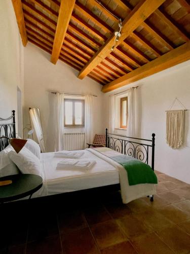 a bedroom with a large bed and a wooden ceiling at Casale Milleluci - Country House in Senigallia