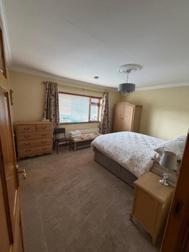 a bedroom with a bed and a dresser and a window at Simple Stay Foxford in Foxford