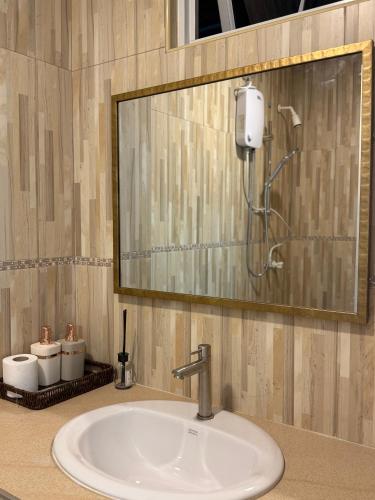 a bathroom sink with a mirror and a shower at Park View Stay in Male City
