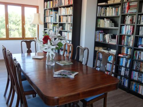 una mesa en una biblioteca con un jarrón de flores en Lagou Raxi Country Hotel, en Lavkos