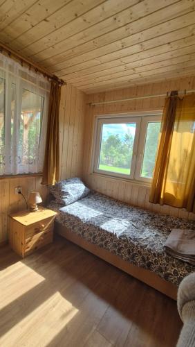 a room with a bed and a window in a cabin at Domki Białogarda in Białogarda