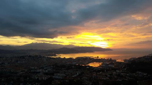 uma vista de uma cidade com o pôr-do-sol ao fundo em La Torretta Rosa em La Spezia