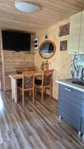 a kitchen and dining room with a table and chairs at Domki Białogarda in Białogarda