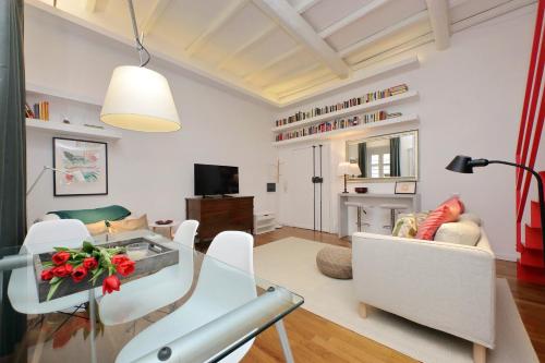 a living room with a glass table and white chairs at 4BNB - Serpenti Delightful Apartment in Rome