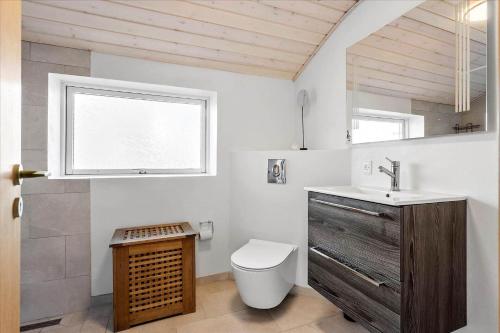 a bathroom with a toilet and a sink and a window at FY175-Asperup-Sommerlandsvej-4 in Asperup