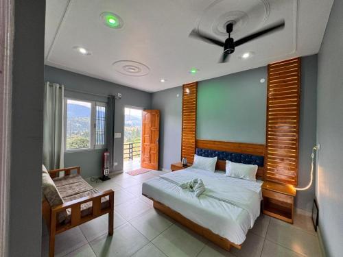 a bedroom with a bed and a couch and windows at Seraahi Hills Resort in Bhadarwāh
