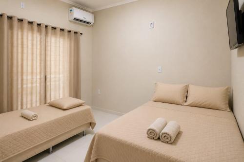 a bedroom with two beds with towels on them at Pousada Economia in Paracatu