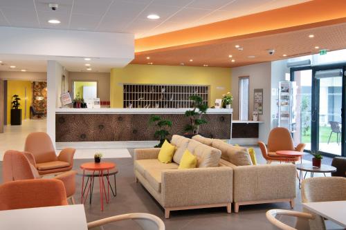 a lobby with a couch and chairs and a bar at DOMITYS - Les Passementiers in Villars