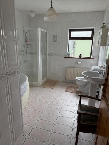 a bathroom with a tub shower and a sink at Simple Stay Foxford in Foxford