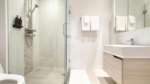 a white bathroom with a shower and a sink at Stylish Diamond Condo Bangtao with Pool View in Bang Tao Beach