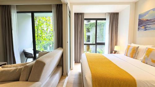 a hotel room with a bed and a couch at Stylish Diamond Condo Bangtao with Pool View in Bang Tao Beach