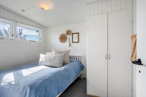 a bedroom with a bed with a blue comforter at FY402-Asperup-Eskelundsvaenget-9 in Voldby