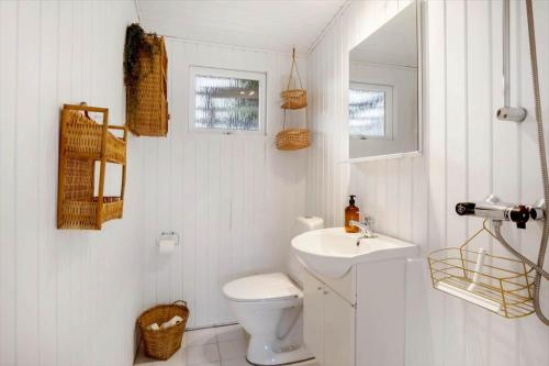 a white bathroom with a toilet and a sink at FY402-Asperup-Eskelundsvaenget-9 in Voldby