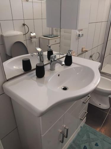 a bathroom with a white sink and a toilet at Eclisse quinto piano senza ascensore in Palermo