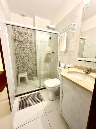 a bathroom with a shower and a toilet and a sink at Flat 3 Quartos Pé na Areia, Piscina e Mar, Summer House Genipabu, Guarajuba in Guarajuba