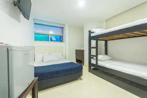 a bedroom with two bunk beds and a television at Hotel Los Angeles Bello in Bello