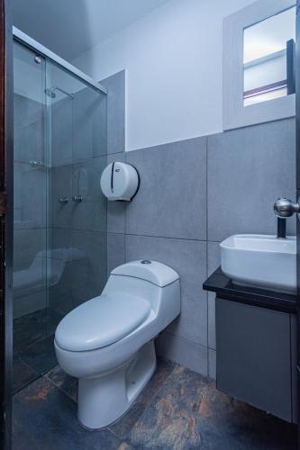 a bathroom with a toilet and a sink at Hotel Los Angeles Bello in Bello