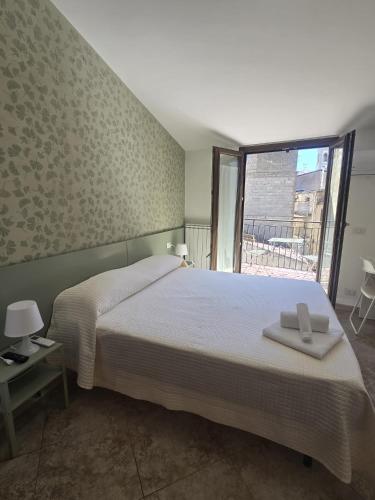 a bedroom with a bed and a large window at B&B Sant'Anna in Lercara Friddi