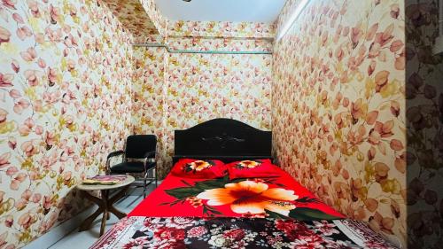 a bedroom with a red bed with a flower on it at Hotel Paradise Residential in Dhaka