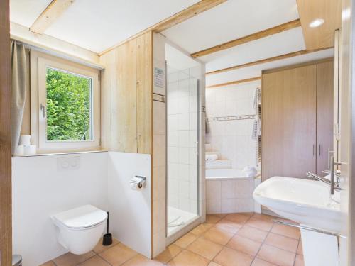 a bathroom with a toilet and a tub and a sink at Guardian Gate Lodge in Iseltwald