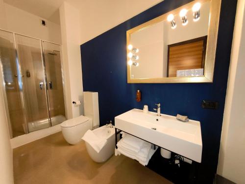 a bathroom with a sink and a toilet and a mirror at Park Hotel Meublé in Como