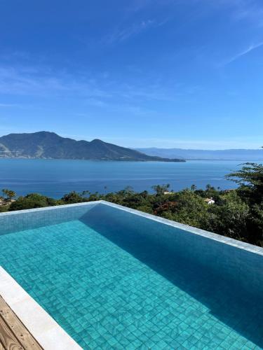 a swimming pool with a view of the water at Casa Gaia GuestHouse in Ilhabela