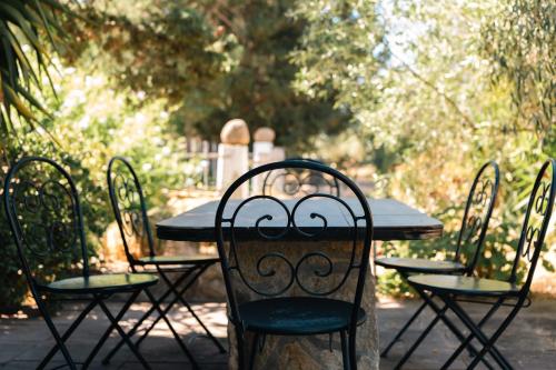a table with four chairs around it in a cemetery at Residenze Camboni in Castiadas