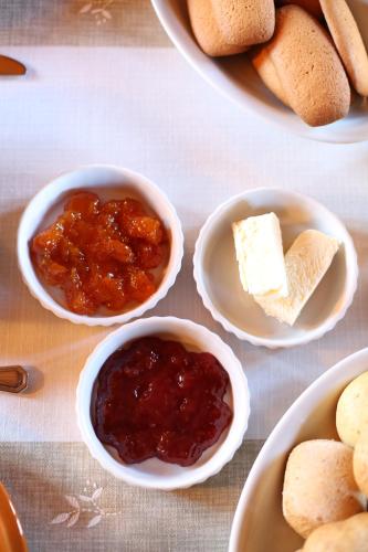 a table with bowls of jam and butter and bread at Guest House I Vicini di Cesare in Castelnuovo