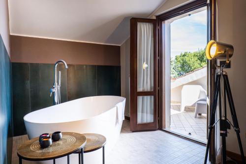 a bathroom with a bath tub and a table at La Ginestra in Fiore Camere in Sirolo