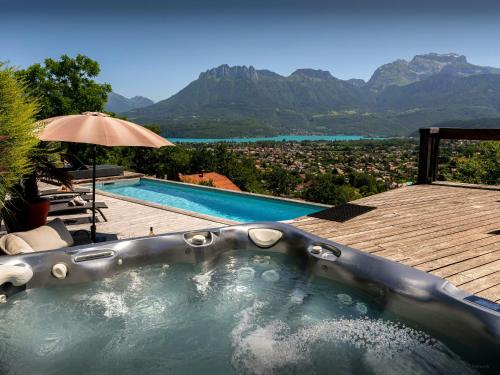 a hot tub with a view of the mountains at Chalet Kalyssia - OVO Network in Saint-Jorioz
