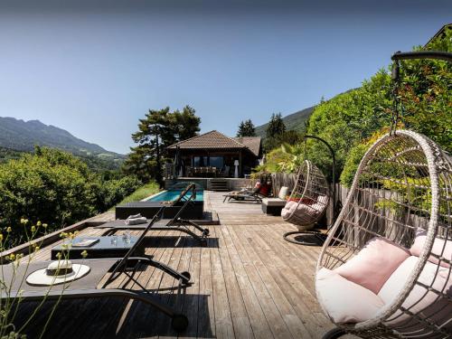 a deck with two swings and a swimming pool at Chalet Kalyssia - OVO Network in Saint-Jorioz