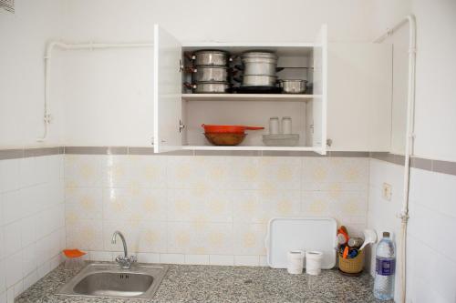 a kitchen with white cabinets and a sink at Jasmin in Gabès