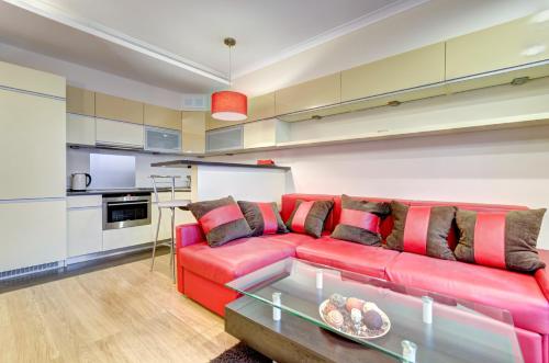 sala de estar con sofá rojo y mesa en Dom & House - Apartamenty Kamienice Nad Motławą, en Gdansk