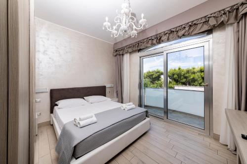 a bedroom with a bed and a large window at Hotel Aurora in Porto Cesareo