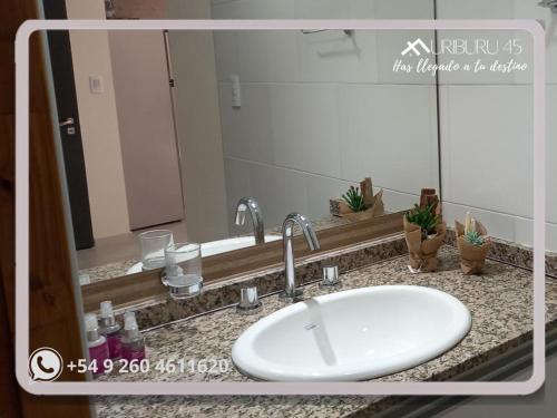 a bathroom counter with a sink and a mirror at uriburu45 in Malargüe