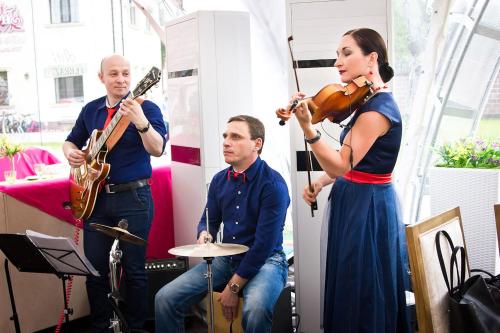 a group of people playing instruments and a woman playing a violin at Park Hotel in Karagandy