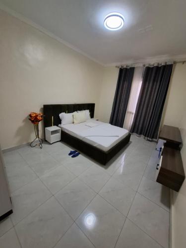 a bedroom with a large bed and a window at Kigali Alba Home in Kigali