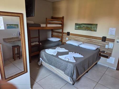 a bedroom with a bed and a bunk bed at Pousada Canto da Praça in Bertioga