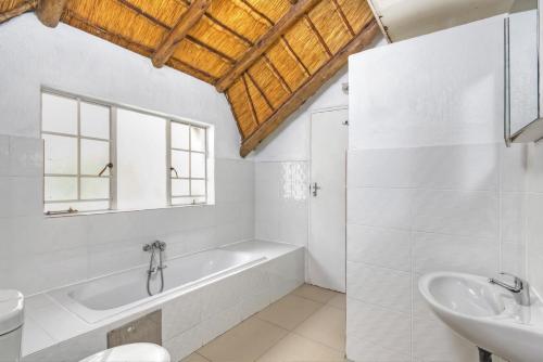 a white bathroom with a tub and a sink at Mandy place in Sandown