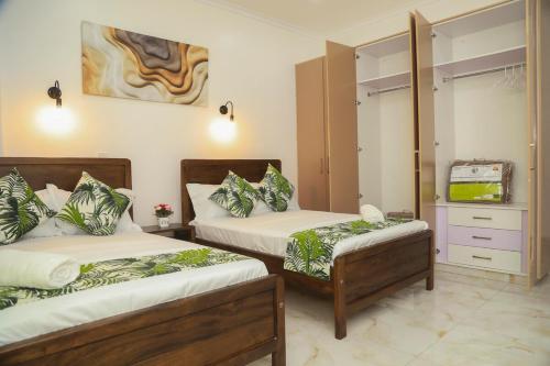 a bedroom with two beds and a tv in it at Coastal Haven 3 Bed Nyali in Mombasa