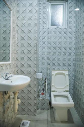 a bathroom with a sink and a toilet and a window at Coastal Haven 3 Bed Nyali in Mombasa