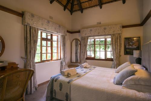 una camera con un grande letto e due finestre di Grace Guest House a Johannesburg