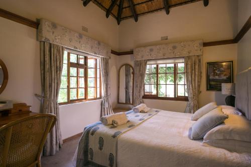 a bedroom with a large bed and two windows at Grace Guest House in Johannesburg