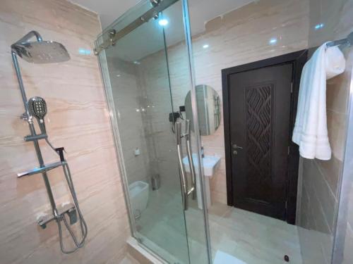 a bathroom with a glass shower with a toilet and a sink at IP Hotels And Towers in Chori