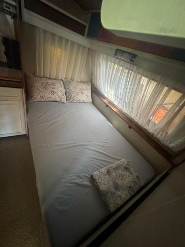 a small white bed in a small room at karavana.ta in Chernomorets