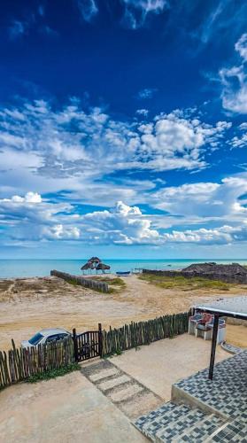 a view of a beach with an umbrella and the ocean at Refugio, Casa de la Playa in Manaure