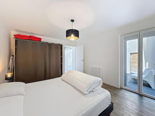 a bedroom with a white bed and a large window at Gite Leny proche Colmar in Ingersheim